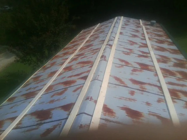 Rusted metal roof panels with new wood purlins before replacement — Storm Damage Roof Repair in Sweeny by Roofing Brothers