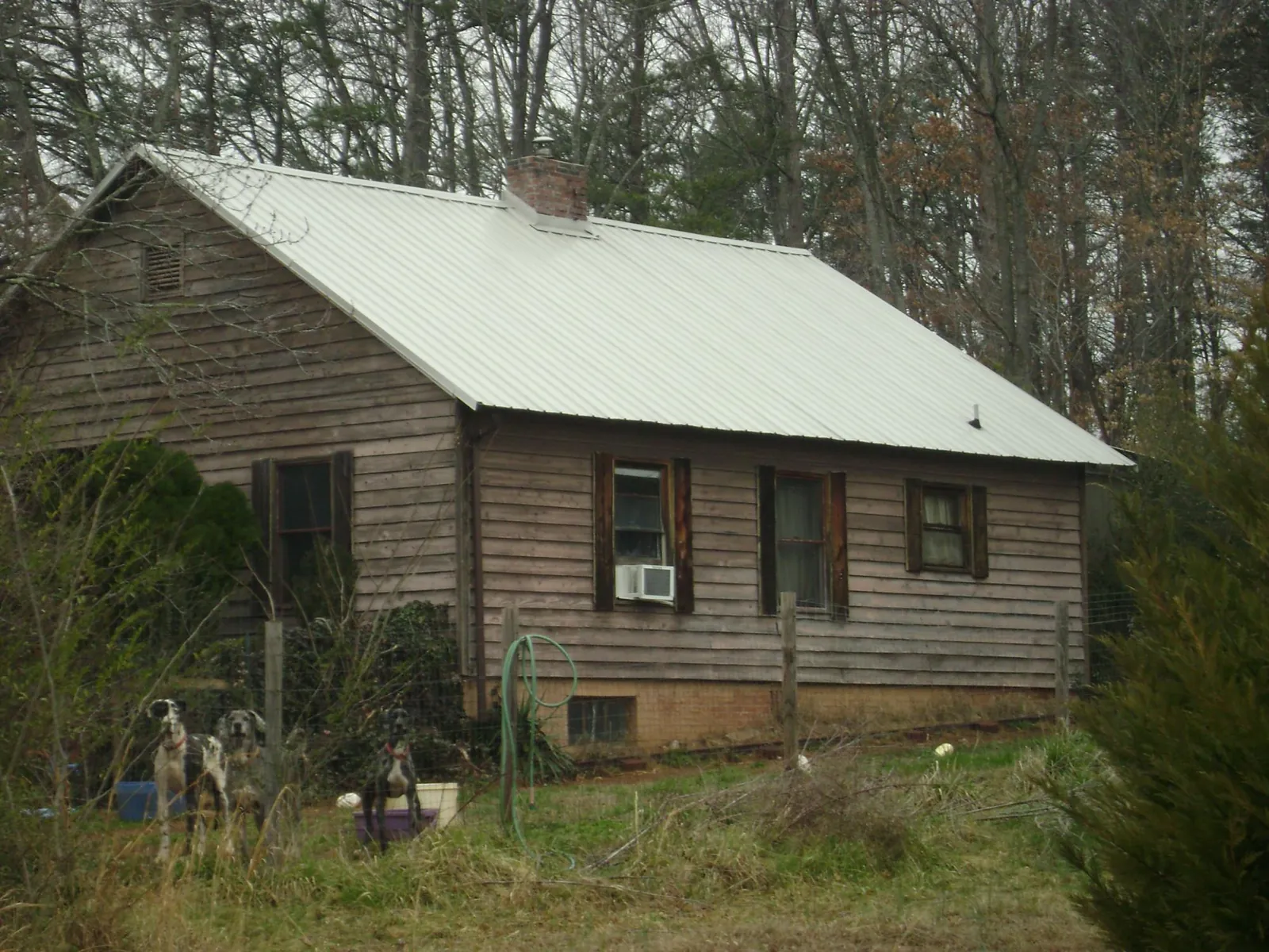 White metal roof on an old wood sided farmhouse, from a Metal Roof Installation job in Sweeny